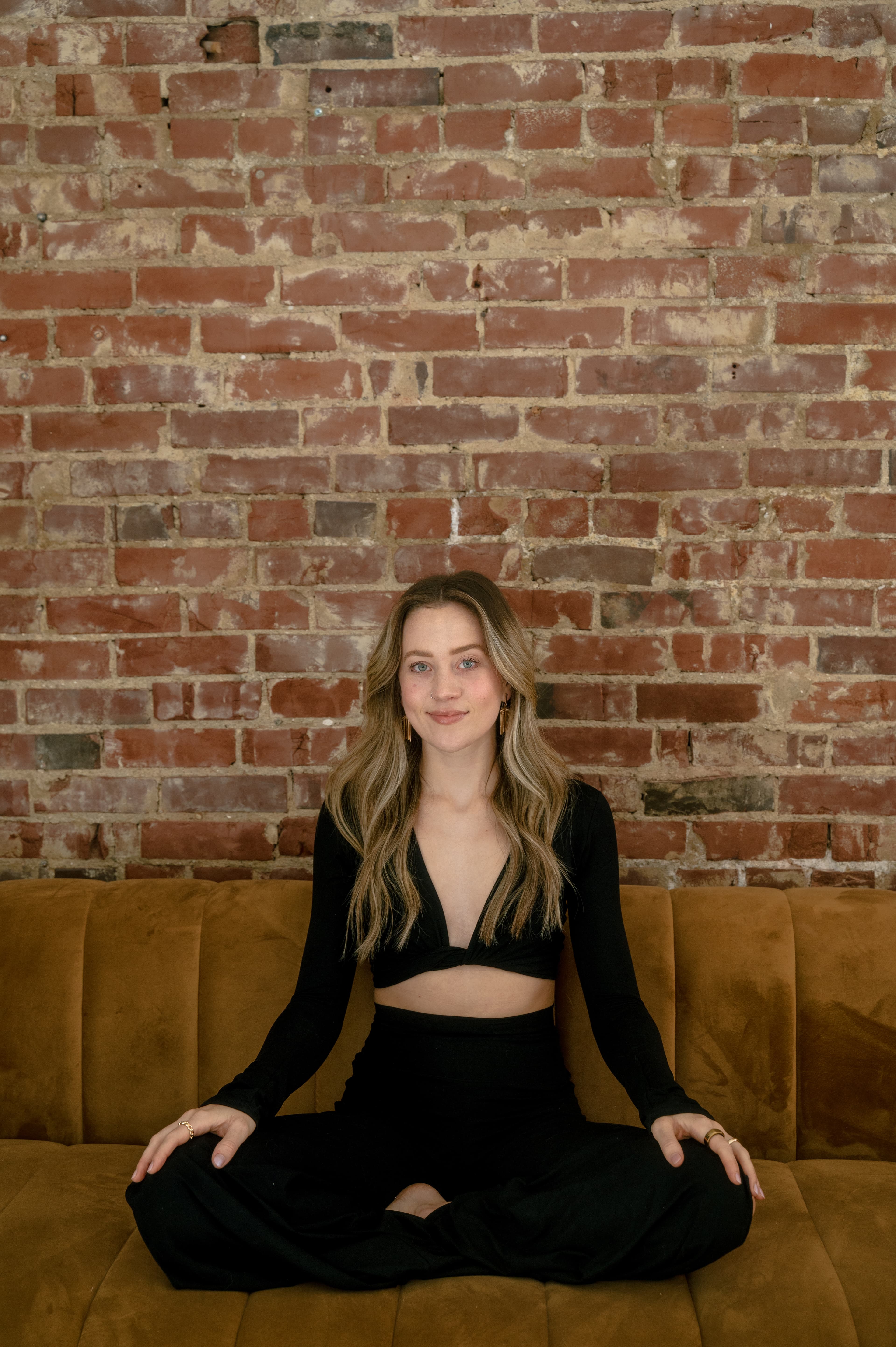 Lindsay seated in front of a brick wall